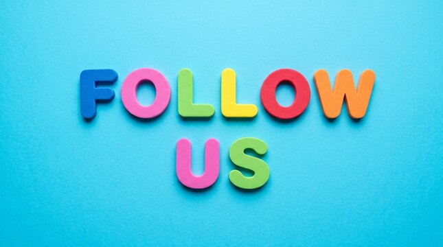 Colorful foam letters spelling out the phrase FOLLOW US arranged centrally on a vibrant blue surface background.
