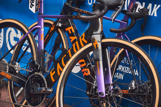 Close-up of Factor OSTRO and VAM road racing bicycles displayed together at a professional cycling event.