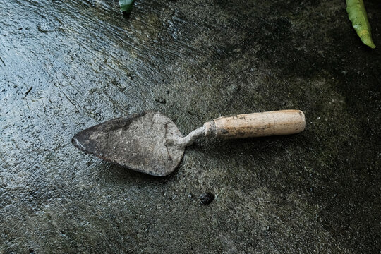 Used Garden Hand Trowel on Wet Concrete Surface