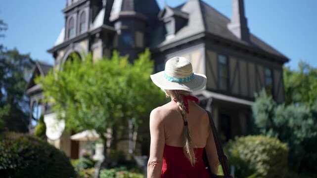 A happy woman strolls through a winery in Napa or Sonoma, enjoying grapes and the lovely surroundings under the sun.