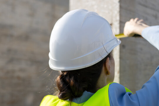Woman engineer measuring construction column working on site