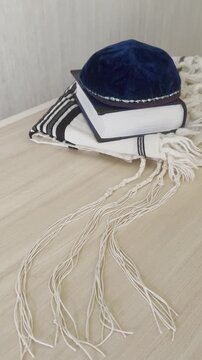 kippah, siddur and tallit on a wooden table, Jewish religious objects