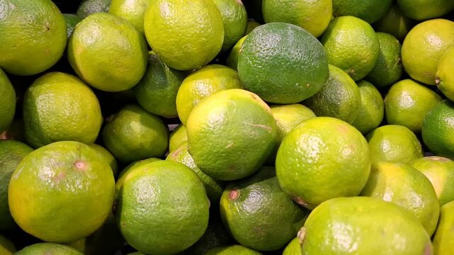Fresh green limes piled together at a grocery market, healthy food choice, tropical produce, natural freshness, summer harvest.