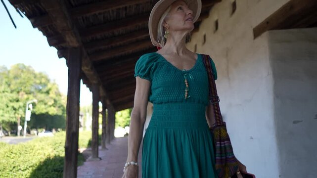 A senior woman smiles as she walks through the historic Mission church in Sonoma, California, taking in the sights and sounds around her.