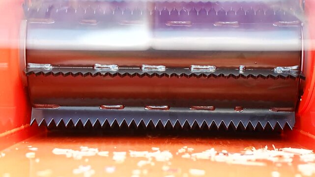 Industrial forestry wood chipper intake feed roller with serrated steel teeth processing timber for renewable biomass fuel production