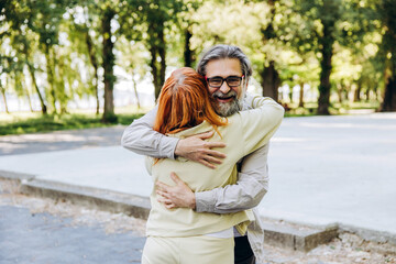 Fototapeta premium Happy senior couple embracing together outdoors in park