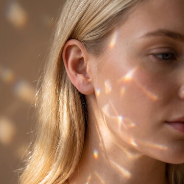 Serene Blonde Woman with Prismatic Rainbow Light on Face