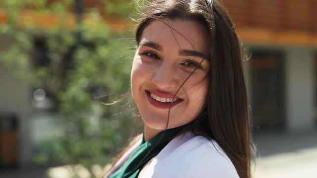 Close up portrait of beautiful happy business woman smiling outdoors, slow motion