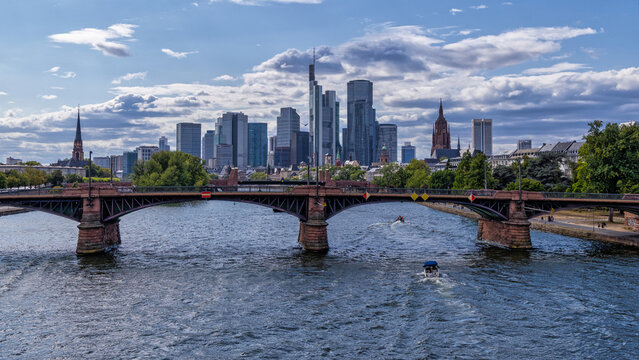 view of the Main river and the Ignatz-Bubis bridge with a cityscape of Frankfurt's financial district
