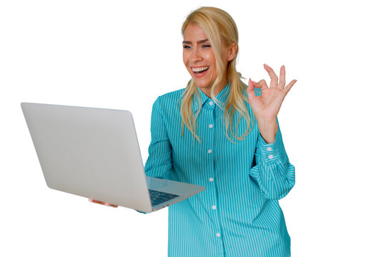 Blonde woman in a turquoise shirt holding a laptop and making an ok gesture, celebrating online success and achievement