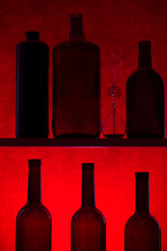 Still life with silhouettes of bottles on a red background