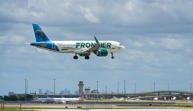 Frontier Airlines aircraft Airbus A320neo landing at the Dallas Fort Worth International Airport (DFW). Crystal the Florida Manatee livery. Storm clouds.