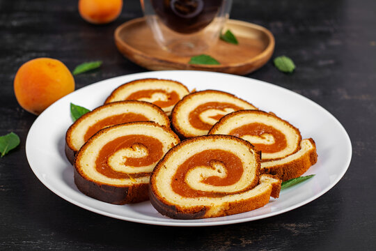 Homemade Apricot Swiss Roll Cake Sliced on White Plate
