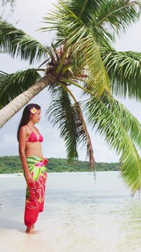 Vacation travel woman on paradise beach holidays vacation on Matira Beach, Bora Bora in pareo and bikini in Tahiti, French Polynesia. Vertical video of real unretouched woman model with no makeup