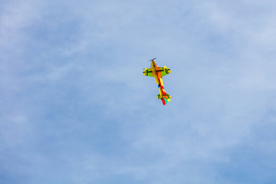 View of a colorful remote-controlled model airplane flying against a clear blue sky in Vilnius, Vilnius County, Lithuania.