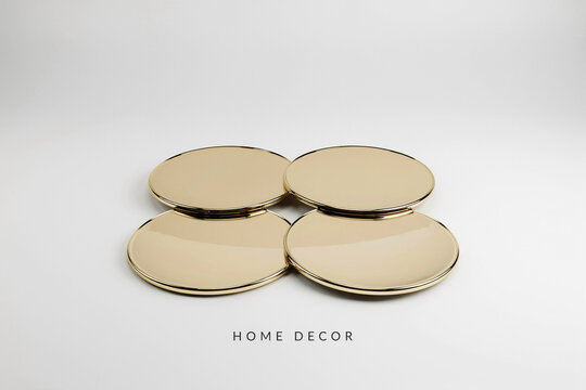 Four golden circular polished reflective metallic items are meticulously arranged in a pristine square pattern showcasing their elegant minimalist design suitable for luxurious modern home decoration