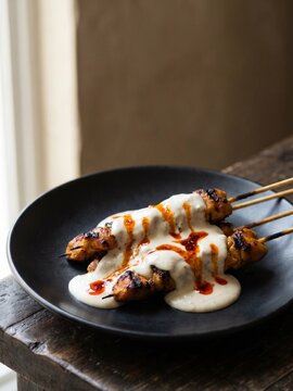 Chicken Satay Skewers Drizzled with Creamy Yogurt Sauce and Chili Oil
