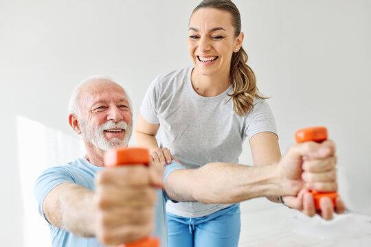 Doctor or nurse or physiotherapist caregiver exercise with senior man at clinic or nursing home