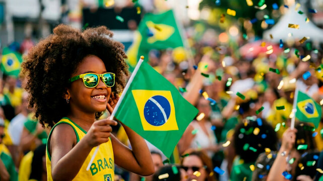 A dark-skinned happy little girl with the flag of Brazil at the Independence Day celebration square