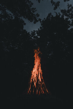 View of a large bonfire burning brightly in the dark forest on Vormsi island in Laane County, Estonia.