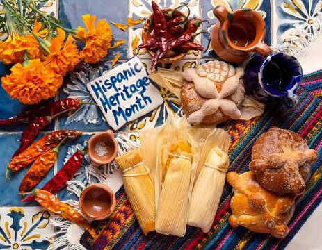 Latin american cuisine flat lay featuring pan dulce tamales marigolds and chili peppers on a colorful tiled surface food mexican central sweet bread conchas