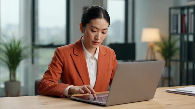 Professional woman working on laptop in a modern office demonstrating remote work productivity and digital lifestyle success