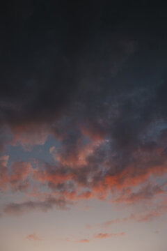 Zosna, Rezekne Municipality, Latvia - 15 July 2024: View of dramatic sunset clouds with vibrant orange and purple hues against a darkening twilight sky.