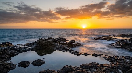 Obraz premium Coastal sunset over rocky shore. Long exposure ocean waves at golden hour.