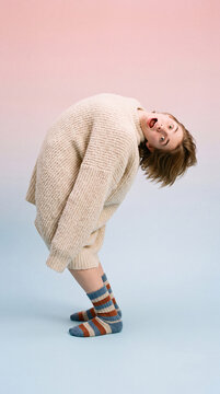 Person Bending Backward Impossibly Far Wearing a Giant Fluffy Sweater with a Surprised Open Mouth Face, Quirky Vertical Mobile Wallpaper