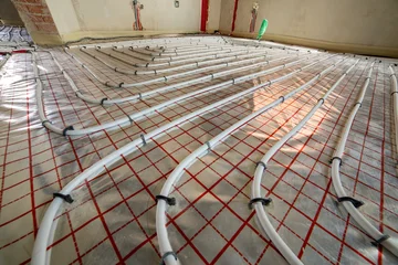 Radiant heating system prepared for concrete covering. Organized pipe layout, modern engineering and energy-efficient residential construction practices. © bilanol