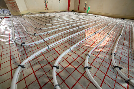 Radiant heating system prepared for concrete covering. Organized pipe layout, modern engineering and energy-efficient residential construction practices.