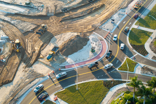 Roadworks construction site at roundabout intersection on American highway. Development of city circular transportation crossroads