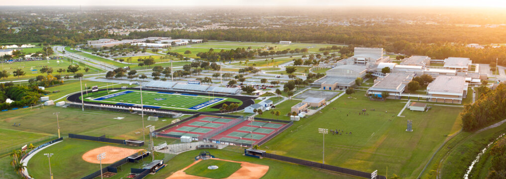 Schoolkids training in American football game on school stadium during physical exercise in North Port, Florida