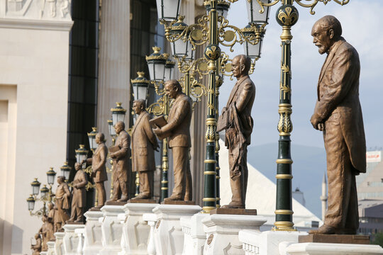 View of bronze statues of historical figures lined up on the Art Bridge with ornate street lamps in Skopje, Greater Skopje, North Macedonia.