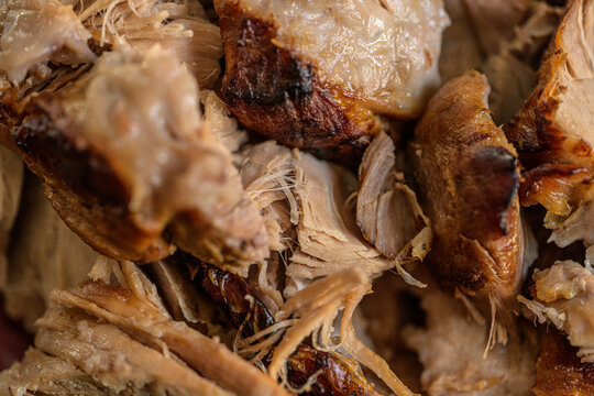 Closeup texture of roasted pork pieces with crispy edges.