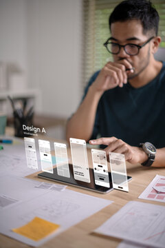 A male designer working on website prototype, in UX UI concept design and development for a website and mobile app prototype, with hologram interface