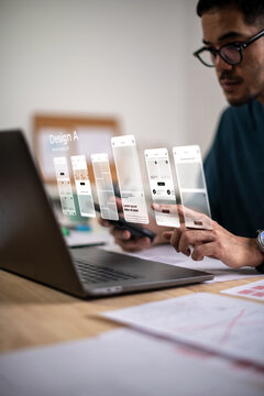 A male designer working on website prototype, in UX UI concept design and development for a website and mobile app prototype, with hologram interface