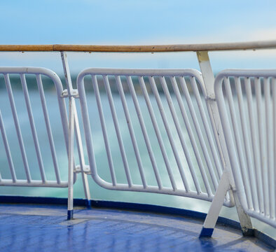 Close view of ferry railing with blurred sea background.