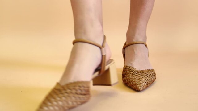 Woman modeling natural woven raffia pointed-toe block heel shoes with ankle straps &ndash; walking, posing and turning on neutral beige background