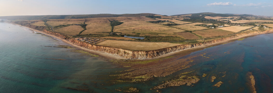 Aerial panoramic view of Compton Bay and Brook Chine Beach on the south-west coast of the Isle of Wight, England, showcasing dramatic cliffs, golden sands, turquoise water, and the spectacular coast