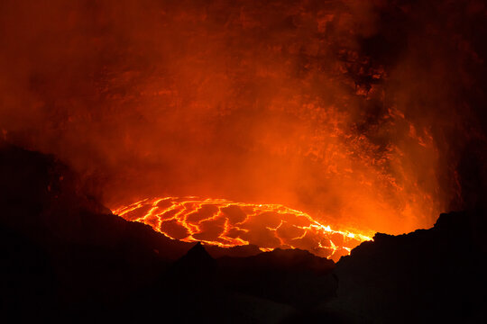 View of the glowing lava lake inside the crater of Erta Ale volcano, with molten rock patterns and dark volcanic rock walls in Zone 2, Afar, Ethiopia.
