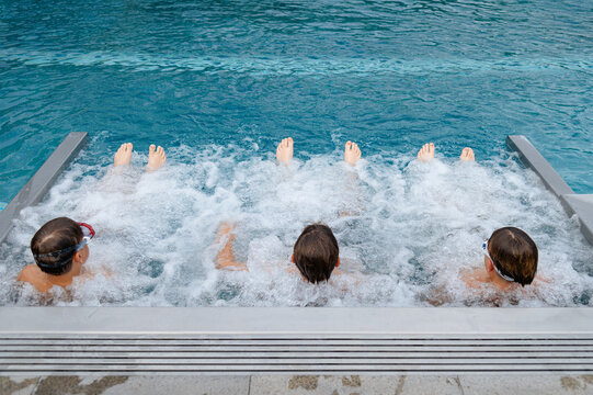Friends relaxing in a hot tub at a poolside in the afternoon