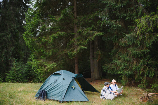 Kids camping in forest learning with laptop