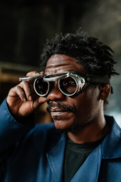 African worker wearing welding glasses preparing for work in a workshop