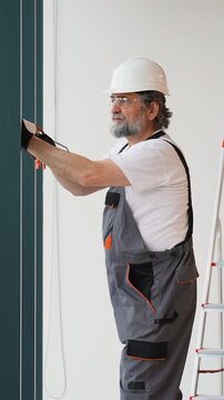 Construction worker applying silicone sealant to a wall