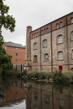 View of a historic red brick industrial building reflected in the canal water in Nottingham, England, United Kingdom.