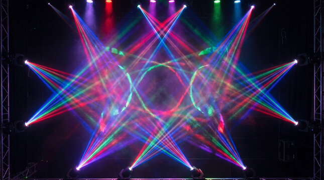 Colorful laser light show beams on a dark stage background