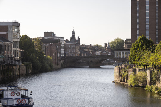 View of the River Ouse flowing through the historic city of York, with the Lendal Bridge in the background, urban architecture, and a boat in the foreground, York, England, United Kingdom.