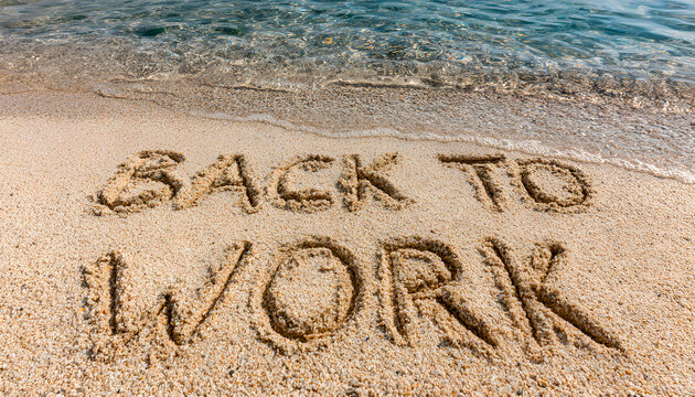 Text "Back to work" written in the sand of the beach, end of summer vacations message in august or september