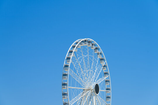 View of a white ferris wheel against a clear blue sky in La Grande-Motte, Occitanie, France.